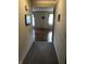 Hallway featuring carpet flooring leading to a living area with hardwood floors and natural light at 3619 31St St, Columbus, IN 47203