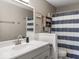 Bathroom featuring a vanity, mirror, towel rack, and shower with a blue and white striped curtain at 3868 E Worthsville Rd, Whiteland, IN 46184