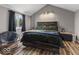 The bedroom boasts a modern bed frame, with natural light shining through a large window at 3868 E Worthsville Rd, Whiteland, IN 46184