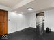 Clean, minimalist room with black floors, white walls, with a door leading to another room at 3868 E Worthsville Rd, Whiteland, IN 46184