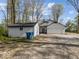 Charming home exterior with a large garage, storage shed, and a gravel driveway surrounded by mature trees at 3868 E Worthsville Rd, Whiteland, IN 46184