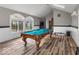 A spacious game room with a pool table under a skylight, featuring views from large windows at 3868 E Worthsville Rd, Whiteland, IN 46184