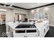 Close-up of the kitchen island, boasting a black stovetop, white countertops, and modern cabinetry at 3868 E Worthsville Rd, Whiteland, IN 46184