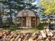 Outbuilding with stacked firewood in the front yard at 3868 E Worthsville Rd, Whiteland, IN 46184