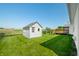 The backyard features a well-maintained shed, a wooden deck, and a lush green lawn under a clear blue sky at 40 Clear Spring Ln, Trafalgar, IN 46181