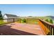 Wooden deck with railing offering scenic views of adjacent green field and clear blue sky in the backyard at 40 Clear Spring Ln, Trafalgar, IN 46181