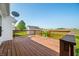 Wooden deck with railing offering scenic views of adjacent green field and clear blue sky and neighborhood shed at 40 Clear Spring Ln, Trafalgar, IN 46181