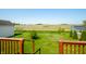 Wooden deck with railing offering scenic views of adjacent green field and clear blue sky and shed at 40 Clear Spring Ln, Trafalgar, IN 46181