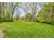 Large green backyard with mature trees providing plenty of space for outdoor activities and recreation at 42 E Brookville Rd, Fountaintown, IN 46130