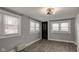 Bedroom with neutral paint, tile floors, three windows and a black door at 42 E Brookville Rd, Fountaintown, IN 46130