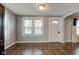 Dining area featuring hardwood floors and natural light, with a view into the entryway at 42 E Brookville Rd, Fountaintown, IN 46130