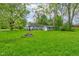 Spacious lot with home, detached garage, and lush green lawn, offering a serene outdoor setting at 42 E Brookville Rd, Fountaintown, IN 46130