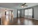 Living room with hardwood floors, gray walls, ceiling fan, and large windows for natural light at 42 E Brookville Rd, Fountaintown, IN 46130