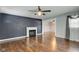 Spacious living room featuring a decorative fireplace, ceiling fan and rich, wood-look flooring at 42 E Brookville Rd, Fountaintown, IN 46130