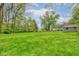 Wide view of the home's large green yard, providing ample space for outdoor activities and gardening at 42 E Brookville Rd, Fountaintown, IN 46130