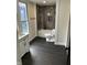 Bathroom features a tub and shower, decorative tile, and black wood-look tile flooring at 44 S Butler Ave, Indianapolis, IN 46219