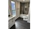 Bathroom features a tub and shower, decorative tile, and black wood-look tile flooring at 44 S Butler Ave, Indianapolis, IN 46219