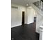 Entryway featuring dark hardwood floors, stairs, and modern trim at 44 S Butler Ave, Indianapolis, IN 46219