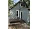 Charming home featuring green siding, a gray front door, and inviting stone steps leading to the entrance at 44 S Butler Ave, Indianapolis, IN 46219