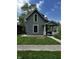 Charming two-story home with a covered front porch, green lawn, and mature trees at 44 S Butler Ave, Indianapolis, IN 46219