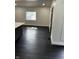 Bright kitchen area featuring dark hardwood floors, a large window, and neutral wall colors at 44 S Butler Ave, Indianapolis, IN 46219
