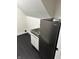 This laundry area features sleek black flooring and a compact refrigerator for added convenience at 44 S Butler Ave, Indianapolis, IN 46219