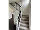 Staircase with carpeted steps and a black metal railing at 44 S Butler Ave, Indianapolis, IN 46219