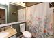 Well-lit bathroom with decorative floral shower curtain, granite sink, and neutral paint at 5077 Vantage Point Rd # 1 Wm-5-1, Avon, IN 46123