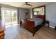 Cozy bedroom with wood floors, ceiling fan, sliding glass doors to balcony and large mirror at 5077 Vantage Point Rd # 1 Wm-5-1, Avon, IN 46123