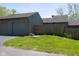 Attached garage and front yard featuring green grass and wooden fence at 5077 Vantage Point Rd # 1 Wm-5-1, Avon, IN 46123