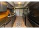 Galley kitchen featuring tile floors, dark cabinets, and stainless steel appliances at 5077 Vantage Point Rd # 1 Wm-5-1, Avon, IN 46123