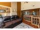 Vaulted living room with a brown leather couch, wood fireplace, and stairs to the upper level at 5077 Vantage Point Rd # 1 Wm-5-1, Avon, IN 46123