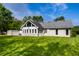 Lush backyard with green grass highlighting home's addition, mature trees, shed, and blue sky at 51 Glasgow Ln, Noblesville, IN 46060