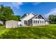 View of the backyard showcasing the lush green grass and the exterior of the home with a sunroom addition at 51 Glasgow Ln, Noblesville, IN 46060