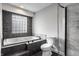 Modern bathroom featuring a mosaic tile accent wall, a soaking tub, and a glass-enclosed shower at 51 Glasgow Ln, Noblesville, IN 46060