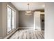 Bright dining area featuring hardwood floors, a modern chandelier, and a large window overlooking the backyard at 51 Glasgow Ln, Noblesville, IN 46060