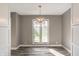 Bright dining area with hardwood floors, a modern chandelier, and a large window overlooking the backyard at 51 Glasgow Ln, Noblesville, IN 46060