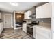 Modern kitchen with stainless steel appliances, white cabinetry, and an adjacent dining area at 51 Glasgow Ln, Noblesville, IN 46060