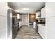 Well-lit kitchen featuring stainless steel appliances, white cabinets, and seamless flow to dining space at 51 Glasgow Ln, Noblesville, IN 46060