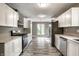 Modern kitchen featuring white cabinets, stainless steel appliances, and a view into a dining area at 51 Glasgow Ln, Noblesville, IN 46060