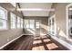 Bright sun room featuring hardwood floors, multiple windows, a white ceiling with exposed beams, and a door to the outside at 51 Glasgow Ln, Noblesville, IN 46060