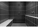 Modern bathroom shower features black tile with white grout, a built-in bench, and updated fixtures at 525 Fynn Pl, Indianapolis, IN 46202