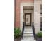 Contemporary townhome featuring a glass front door, brick and stone accents, and a welcoming entrance at 525 Fynn Pl, Indianapolis, IN 46202
