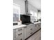 Updated kitchen with stainless steel range hood, dark backsplash, gray cabinetry, and an abundance of natural light at 525 Fynn Pl, Indianapolis, IN 46202
