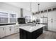 This kitchen has modern white cabinetry, a black island, stainless steel appliances, and lots of natural light at 525 Fynn Pl, Indianapolis, IN 46202