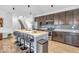 Modern kitchen with stainless steel appliances, a gray backsplash, an island with bar seating, and abundant cabinet space at 5256 Bramwell Ln, Whitestown, IN 46075