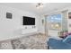 Bright living room with modern light fixture, flat-screen TV, and plush blue sofa at 5256 Bramwell Ln, Whitestown, IN 46075
