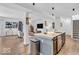 Open-concept kitchen with a spacious island, stainless steel sink, ample storage, and view into the living room at 5256 Bramwell Ln, Whitestown, IN 46075
