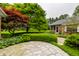 Landscaped backyard with a stone patio is surrounded by mature trees and lush greenery at 5356 S U.S. Highway 421, Zionsville, IN 46077