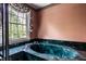 Bathroom features a green marble-clad soaking tub with decorative wallpaper and window with floral valance at 5356 S U.S. Highway 421, Zionsville, IN 46077